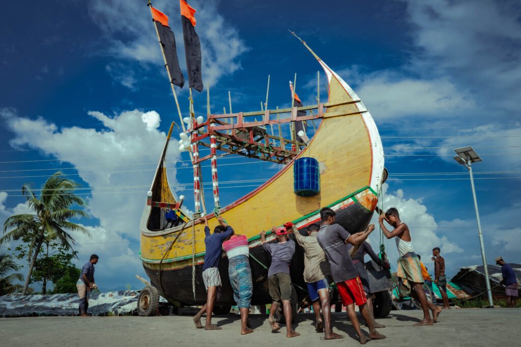 men are shoving/pushing boat
